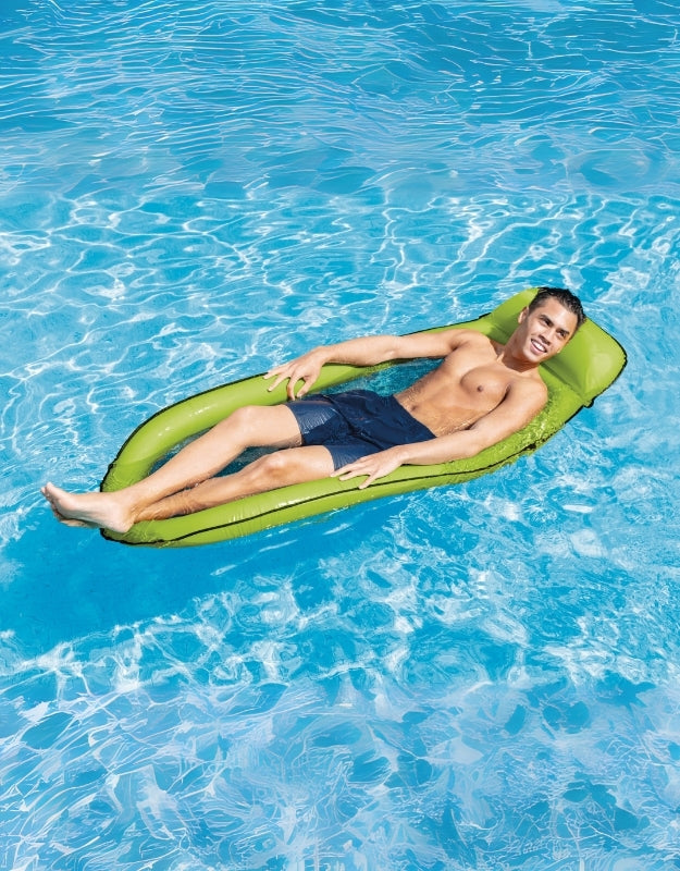 A person relaxing on the green inflatable net recliner in a pool